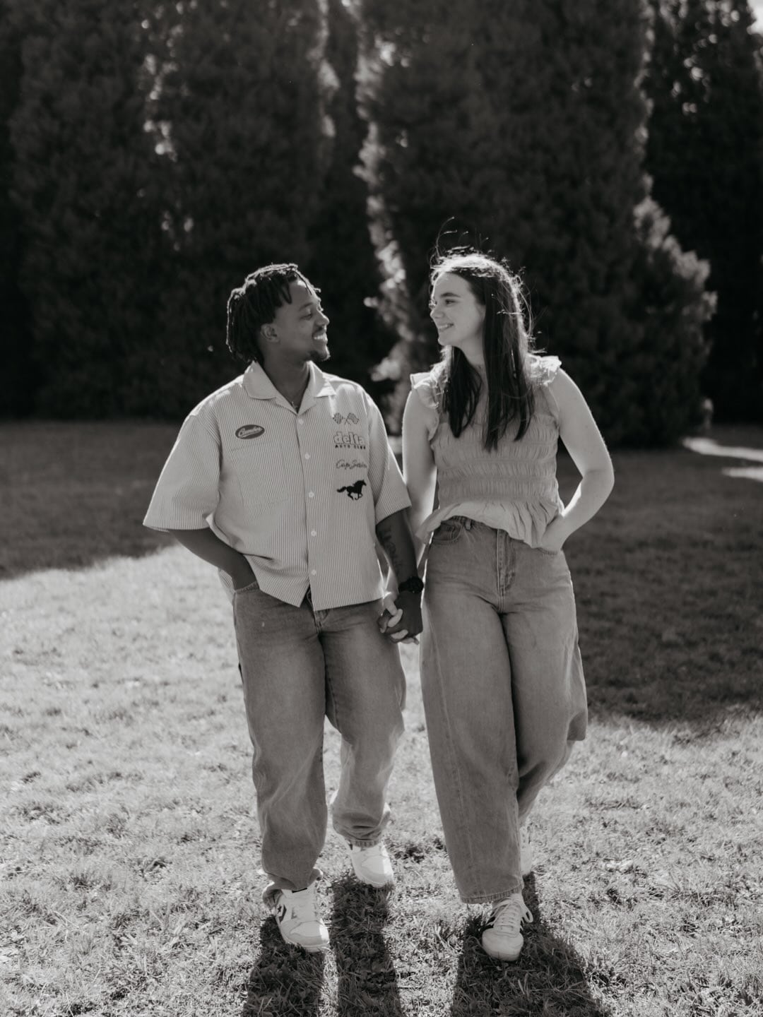 Black-and-white portrait of Amelia and Quinton walking hand in hand