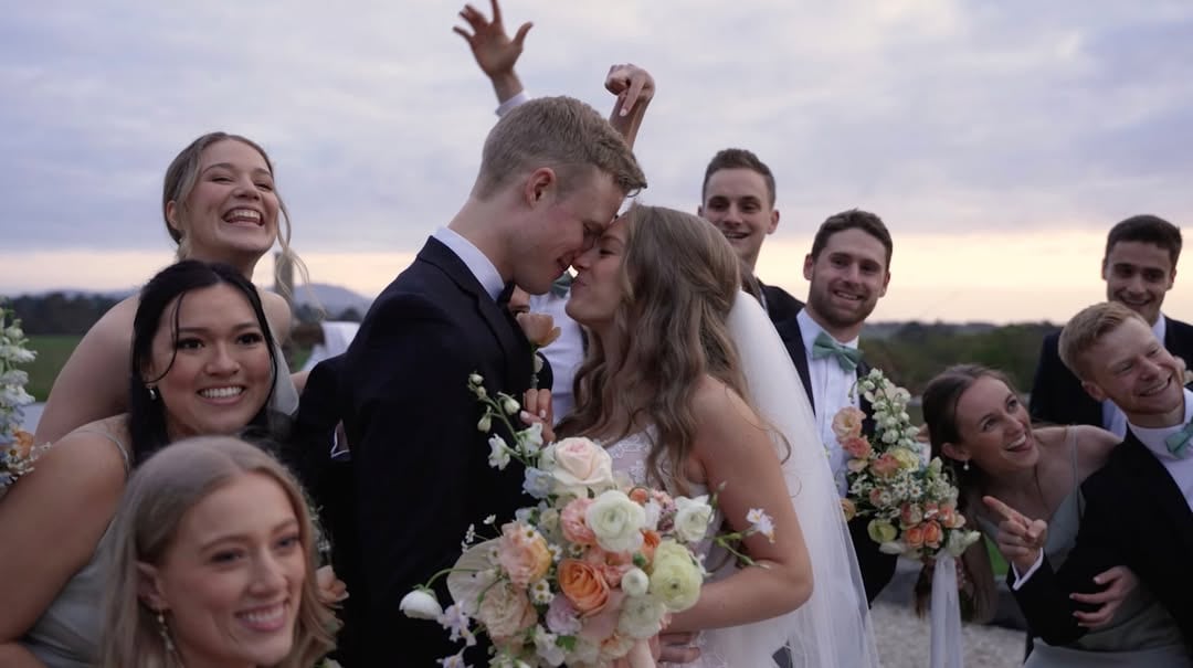 Wedding film still of friends celebrating around the newly married couple