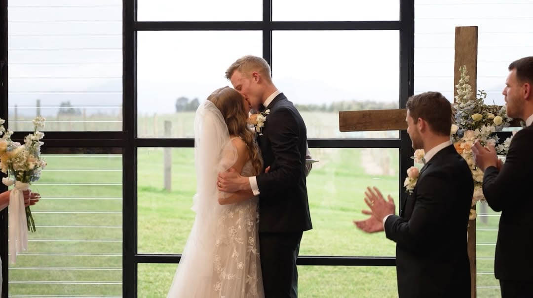 Wedding film still of the couple embracing during their ceremony